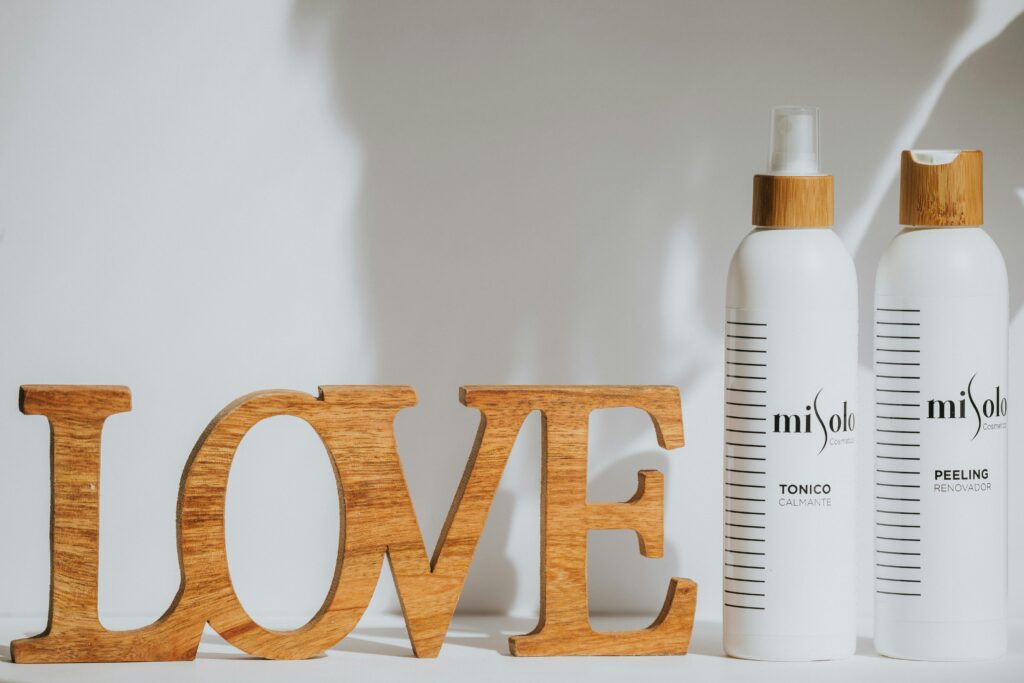 Stylish still life with Misolo skincare bottles and a wooden 'Love' sign on a neutral background.